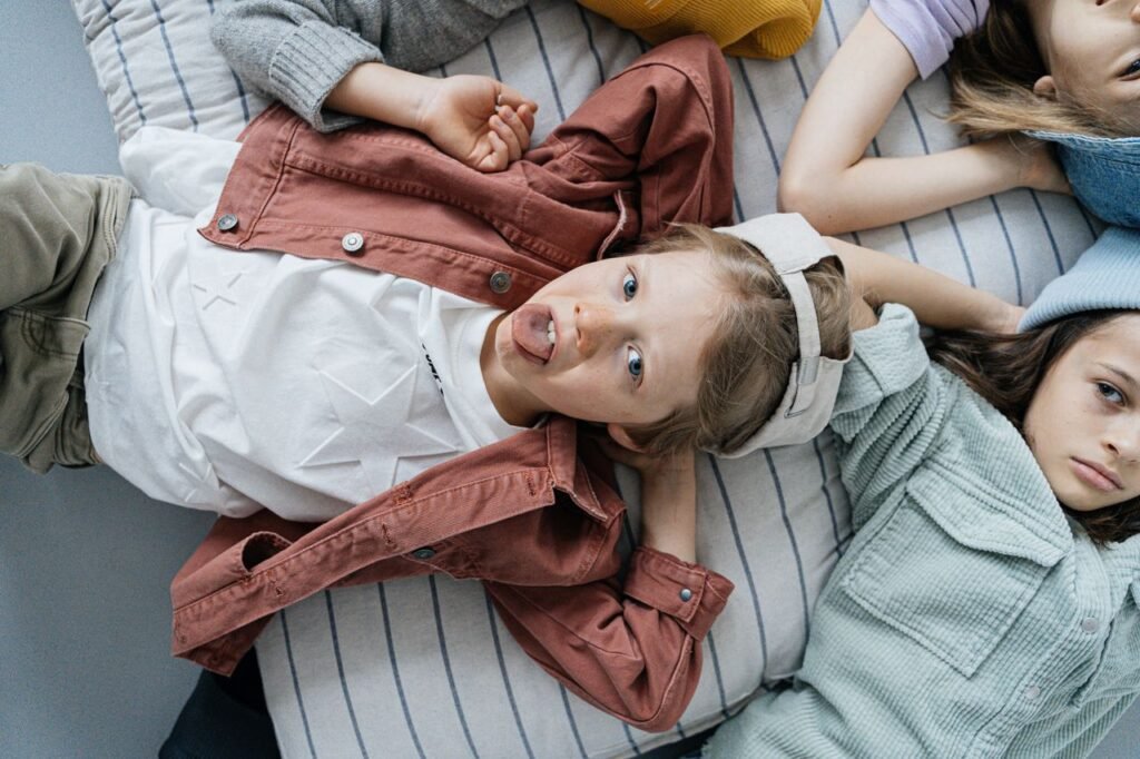 A candid shot of playful children lounging indoors, showcasing carefree youth.